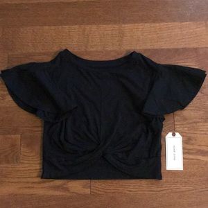 Very cropped black tee with flared sleeves